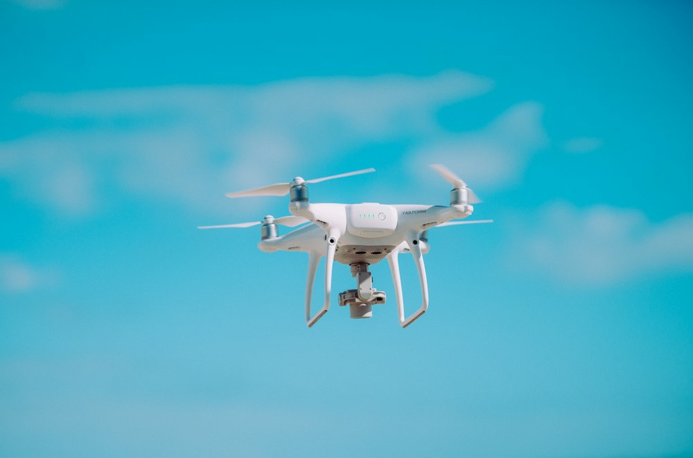 White drone flying in a blue sky
